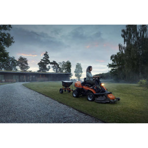 Person cutting grass on Husqvarna R216T AWD towing trrailer